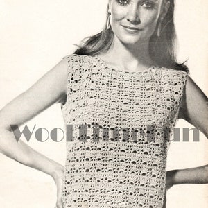 May include: A crochet top with a sleeveless design and a delicate openwork pattern. The top is made with a light-coloured yarn and has a round neckline.