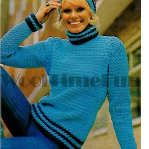 Puede incluir: Un suéter de punto azul claro y un gorro a juego con rayas y ribetes azul oscuro. El suéter tiene cuello alto y mangas largas. El sombrero es de estilo gorro. La persona lleva vaqueros azules.