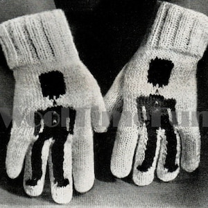 May include: A pair of white knitted mittens with black knit figures of stick people on them.