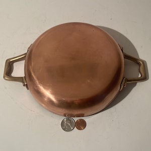 Op de afbeelding: Koperen pan met messing handvatten. De pan is leeg en heeft een glanzende koperen afwerking.
