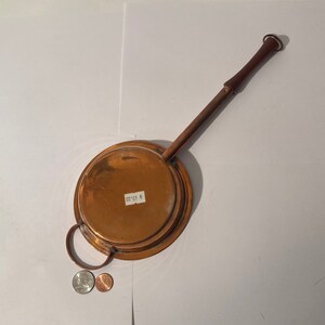Könnte beinhalten: Kupferpfanne mit Holzgriff und einem Preisschild mit der Aufschrift "00.69 $".
