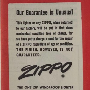 May include: A vintage advertisement with a red background and white text. The text reads "Please... Our Guarantee is Unusual" and details the Zippo lighter guarantee. The Zippo logo is prominently displayed, along with the company's address in Bradford, PA.