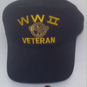 Könnte beinhalten: Eine schwarze Baseballkappe mit einem goldenen gestickten Aufnäher, auf dem "WW II VETERAN" mit einem Adlermotiv steht.