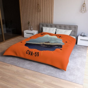 Könnte beinhalten: Orange-blaue Bettwäsche mit einem Vintage-Bild des Flugzeugträgers USS 'Constellation', mit dem Text 'USS Constellation' und 'CVA-59' in Schwarz.