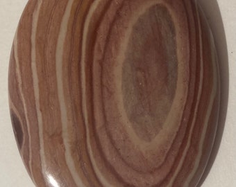 May include: A bolo tie with a large, oval-shaped stone. The stone is a light brown color with white stripes running through it.