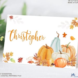 May include: Printable place card featuring the name "Christopher" in orange script. The card is decorated with watercolor illustrations of pumpkins, gourds, and fall leaves in shades of orange, yellow, and green.