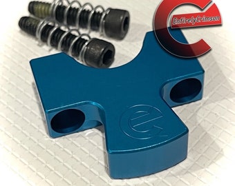 May include: A teal blue metal part with two holes on each side and a logo on the bottom. Two small springs and screws are included.