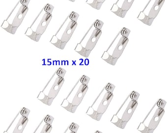 May include: Twenty silver-toned metal pin backs, each measuring 15mm in diameter. The pin backs have a spring-loaded mechanism and a flat back.