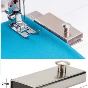 May include: A silver magnetic sewing machine fabric holder measuring 7mm in height, 24mm in width, and 54mm in length. The holder has a small knob on top.