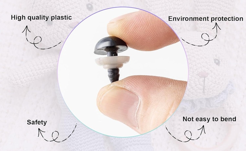 May include: Close-up of a black plastic safety eye with a white washer. The eye is being held by a hand. The text "High quality plastic", "Environment protection", "Safety", and "Not easy to bend" are visible around the eye.