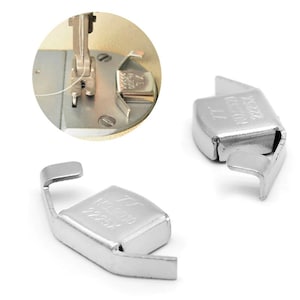 May include: Two silver magnetic thread holders for a sewing machine. The holders are designed to hold thread in place while sewing. The holders are shown in two different positions, one with the magnet facing up and the other with the magnet facing down.