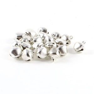 May include: A pile of silver jingle bells, ideal for adding a festive touch to crafts, decorations, or gifts.