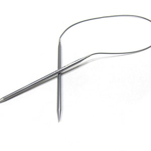 May include: A pair of silver knitting needles with a circular cable. The needles are crossed and the cable is looped.