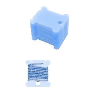 May include: A stack of 10 blue plastic thread bobbins and a blue plastic thread bobbin with blue thread wound around it.