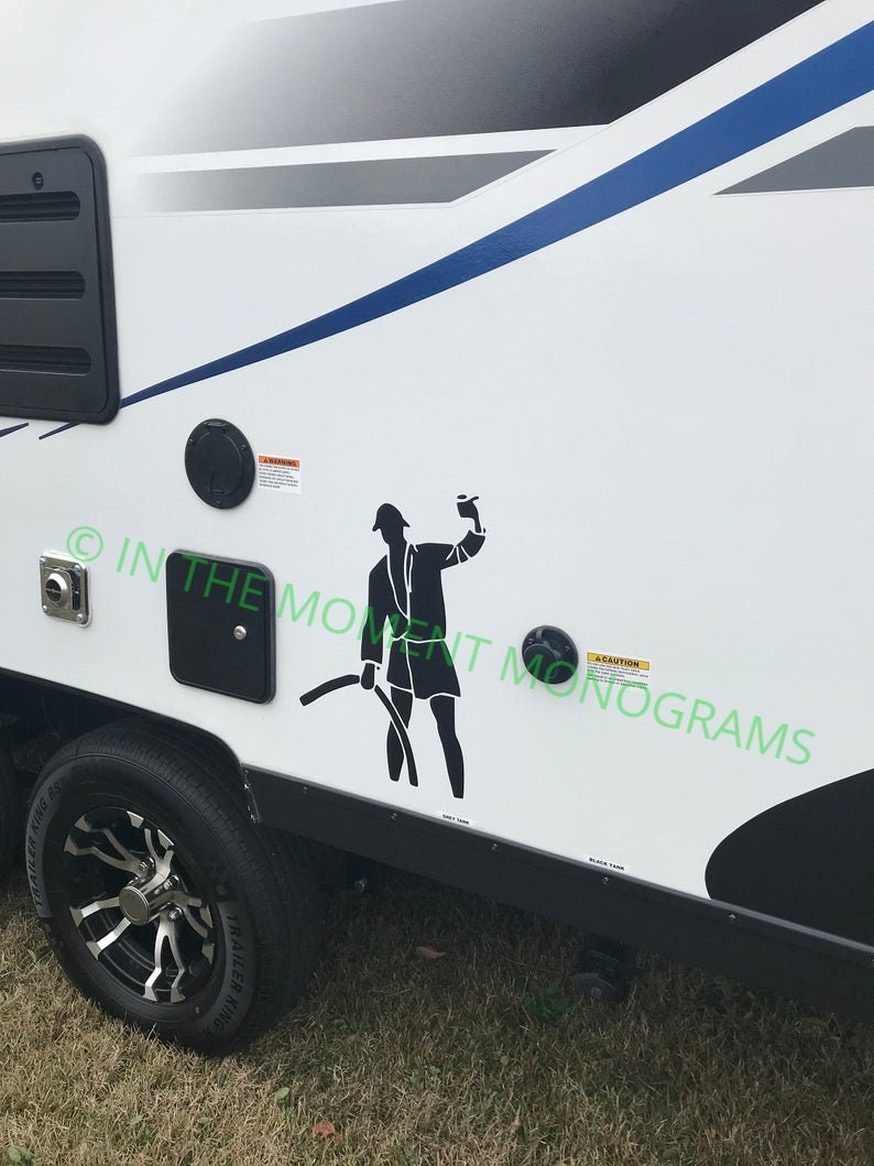 May include: A white camper with a black silhouette of a person holding a hose. The camper has a black trim and a blue stripe. The text "CAUTION" is visible on the camper.