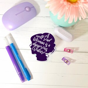May include: A purple silhouette of a woman's head with the text "A well read woman is a dangerous creature" in white.