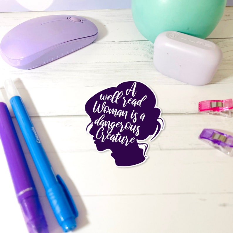 May include: A purple silhouette of a woman's head with the text "A well read woman is a dangerous creature" in white.