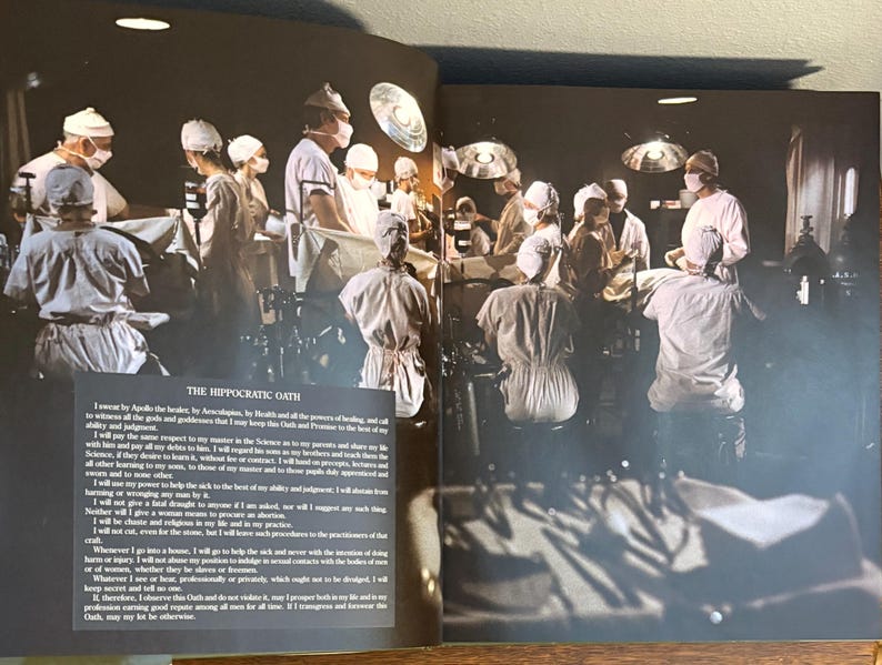 Op de afbeelding: Een vintage foto toont een operatiekamer met meerdere medische professionals in witte jassen, mutsen en maskers. Heldere overheadverlichting verlicht de kamer. De tekst "THE HIPPOCRATIC OATH" is zichtbaar.