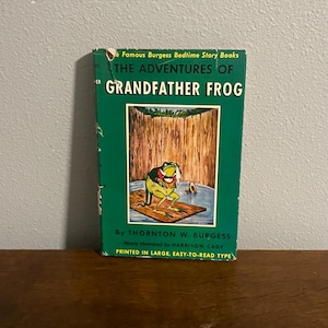 May include: A green book cover with the title "The Adventures of Grandfather Frog" by Thornton W. Burgess. The cover features an illustration of a frog sitting on a log in a pond.