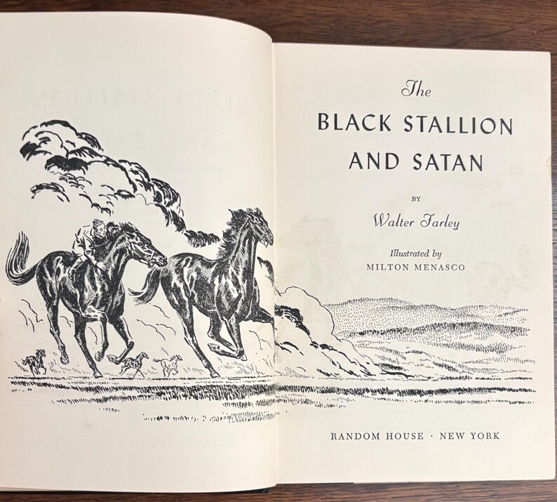 May include: Open book with the title "The Black Stallion and Satan" by Walter Farley, illustrated by Milton Menasco. The illustration features two black horses running across a field, with a rider on one. The book is published by Random House, New York.