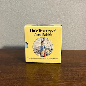 May include: A yellow box set titled "Little Treasury of Peter Rabbit" with a circular illustration of Peter Rabbit in a blue jacket. The box includes text "With Full-Color Illustrations by Beatrix Potter".