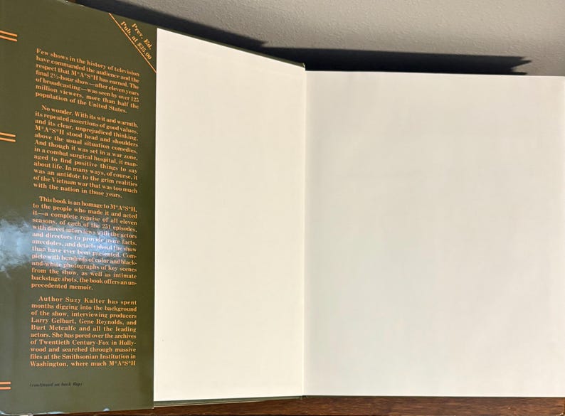 Op de afbeelding: Open boek met een groene kaft en witte pagina's. De linkerpagina heeft zwarte tekst, inclusief de titel en de naam van de auteur. De rechterpagina is leeg. Het boek ligt op een houten oppervlak.