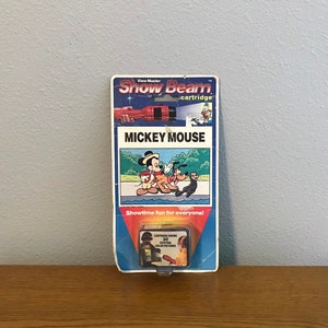 Könnte beinhalten: Eine View-Master Show Beam-Kartusche mit Mickey Mouse. Die Kartusche zeigt 30 spannende Farbbilder. Die Vorderseite der Verpackung zeigt ein Cartoon-Bild von Mickey Mouse, Pluto und Goofy.