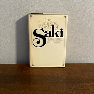 May include: A white book with a black title that reads "The Complete Works of Saki" with an introduction by Noel Coward. The book is by H.H. Munro.