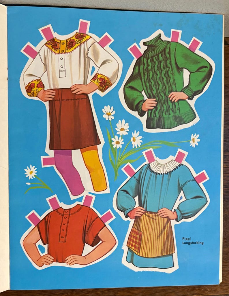 May include: A paper doll sheet featuring Pippi Longstocking with four outfits: a white blouse with floral embroidery and a brown skirt, a green cable-knit sweater, a red short-sleeved shirt, and a blue dress with a striped apron and white collar.