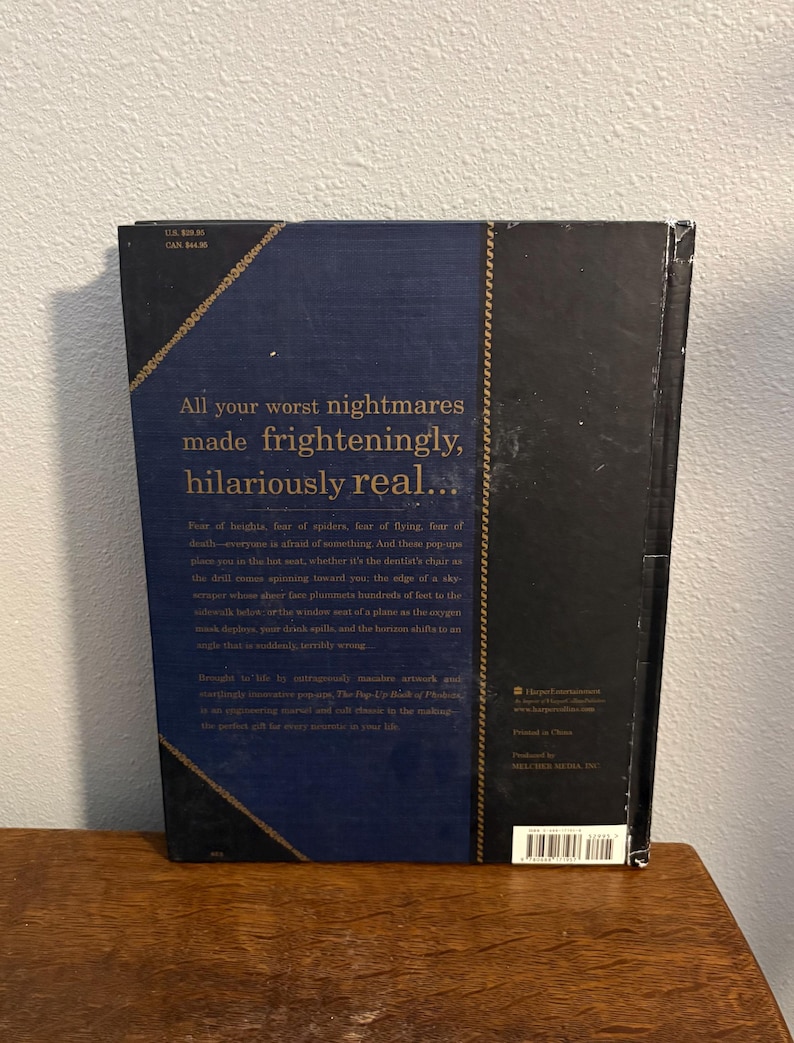 May include: A hardcover book with a dark blue cover and gold text. The title reads "All your worst nightmares made frighteningly, hilariously real..." The book has a textured spine and a decorative border.