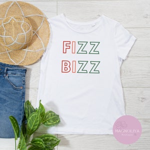 May include: White t-shirt with the text "FIZZ BIZZ" in green and red outlined letters.