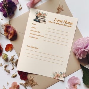 Pu&ograve; includere: Una carta color crema "Love Notes" con decorazioni floreali e linee per scrivere, su una busta beige. La carta include il testo "Advice & wishes for the couple" e suggerimenti per consigli. Fiori rosa, rossi e viola sono sparsi.