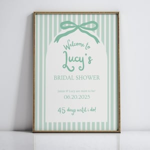 以下が含まれることがあります： ミントグリーンと白のストライプのブライダルシャワーのサイン。リボンと「Welcome to Lucy's Bridal Shower. Jamie & Lucy are mint to be! 06.20.2025 45 days until I do!」のテキストが書かれています。