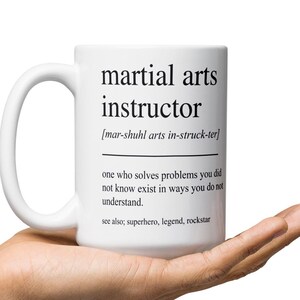 May include: White ceramic mug with the words "martial arts instructor" printed in black. The mug also includes a definition and the words "see also; superhero, legend, rockstar."