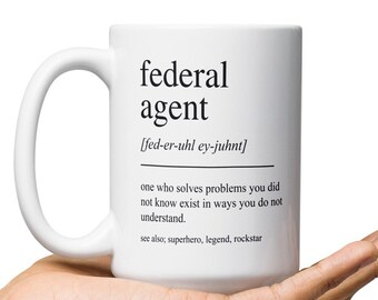 May include: White ceramic mug with a black design that reads "federal agent [fed-er-uhl ey-juhnt] one who solves problems you did not know exist in ways you do not understand. see also, superhero, legend, rockstar"