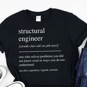 May include: Black t-shirt with white text that reads "structural engineer [struhk-cher-uhl en-juh-neer] one who solves problems you did not know exist in ways you do not understand. see also; superhero, legend, rockstar"