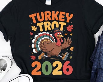 May include: Black t-shirt with the text "TURKEY TROT 2026" and a cartoon turkey illustration. The image also includes a pair of white sneakers and blue jeans.