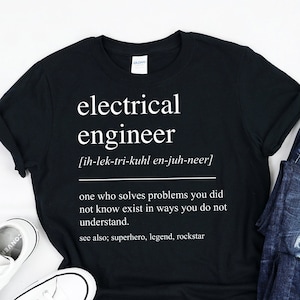May include: Black t-shirt with white text that reads "electrical engineer [ih-lek-tri-kuhl en-juh-neer] one who solves problems you did not know exist in ways you do not understand. see also; superhero, legend, rockstar"