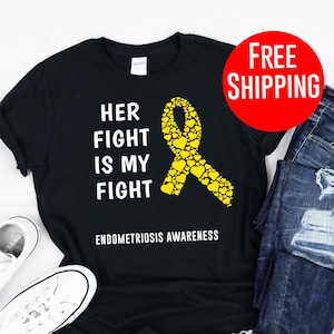 May include: Black t-shirt with a yellow ribbon made of hearts and the text "Her Fight Is My Fight" and "Endometriosis Awareness".