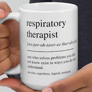 Puede incluir: Taza de cerámica blanca con la inscripción "respiratory therapist" en negro, junto con una definición y términos relacionados. La taza está sujeta por una persona.