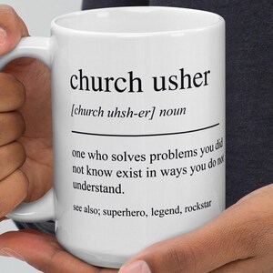 Puede incluir: Taza de cerámica blanca con la inscripción "church usher" y su definición. La definición dice: "alguien que resuelve problemas que no sabías que existían de la forma en que entiendes". La taza también incluye las palabras "superhero, legend, rockstar."