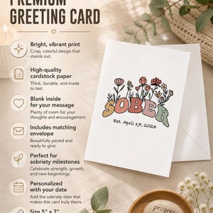 May include: A white greeting card with the word "SOBER" in colorful letters and floral accents. The card is 5" x 7" and includes the date "Est. April 17, 2023". The card is designed for sobriety milestones.