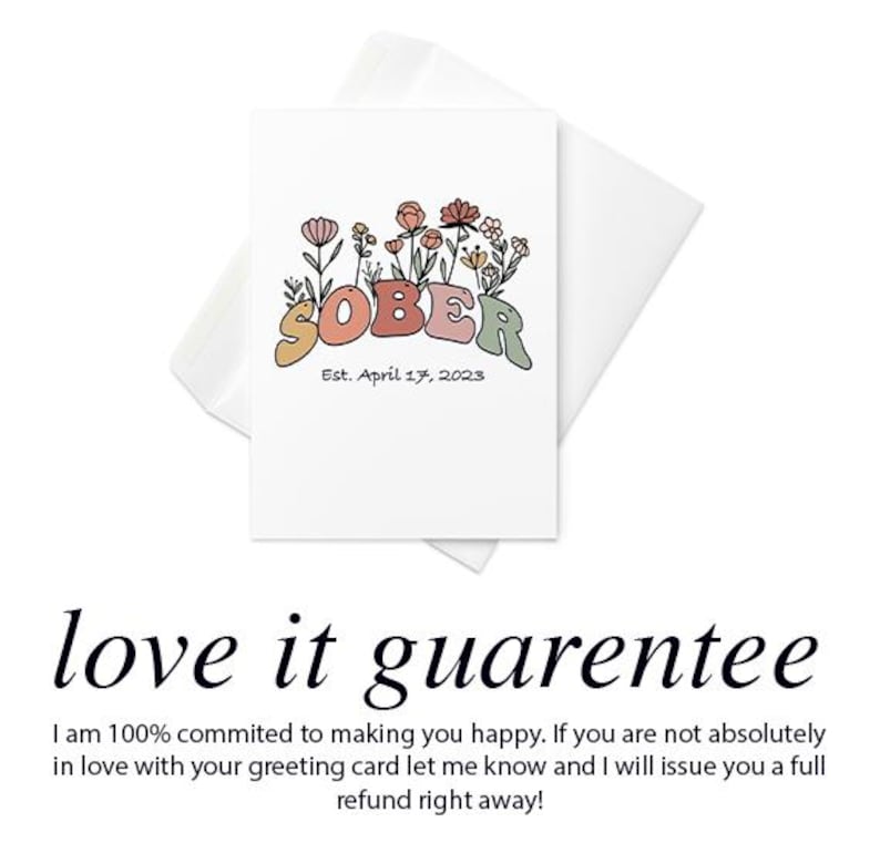 May include: A white greeting card with the word "SOBER" in colorful letters, surrounded by floral illustrations. The text "Est. April 17, 2023" is below the word. The card is inside a white envelope.