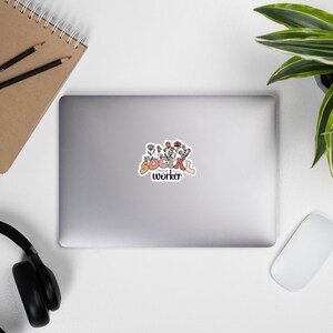 K&ouml;nnte beinhalten: Ein Aufkleber mit einem floralen Design und dem Text "SOCIAL worker" in einer bunten, Retro-Schrift.