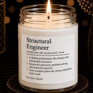May include: A white candle in a clear glass jar with a lit wick. The label features the text Structural Engineer, a phonetic pronunciation, and a definition describing a professional who designs safe structures, precision, and technical expertise.