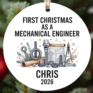 May include: Round white Christmas ornament with the text "FIRST CHRISTMAS AS A MECHANICAL ENGINEER" and "CHRIS 2026". The ornament features engineering tools and blueprints. A festive holiday decoration.