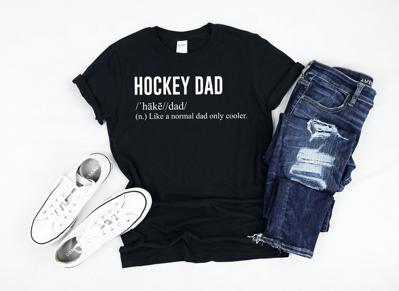 May include: Black t-shirt with white text that reads "HOCKEY DAD /'h&auml;kē//dad/ (n.) Like a normal dad only cooler."