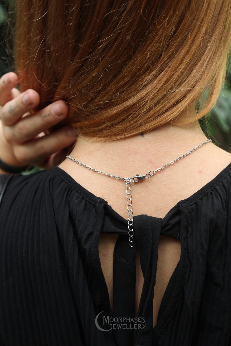 Pode incluir: Um colar de prata com corrente e extensor &eacute; usado no pesco&ccedil;o de uma pessoa. A pessoa est&aacute; usando um top preto com um detalhe de la&ccedil;o nas costas. O logotipo Moonphases Jewellery &eacute; vis&iacute;vel.