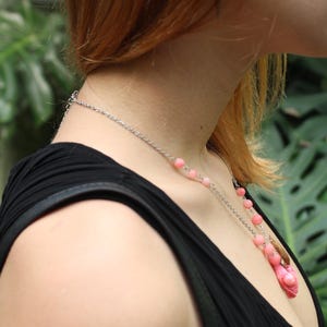 Pode incluir: Um colar de corrente prateada com contas rosa e um pingente rosa. O colar &eacute; usado sobre um top preto. O logotipo Moonphases Jewellery &eacute; vis&iacute;vel na parte inferior.
