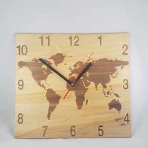 Puede incluir: Un reloj de pared rectangular de madera con un diseño de mapa del mundo. La esfera del reloj es de madera clara con un mapa del mundo de madera más oscura. Agujas de horas y minutos negras y un segundero rojo. Números del 1 al 12 grabados.